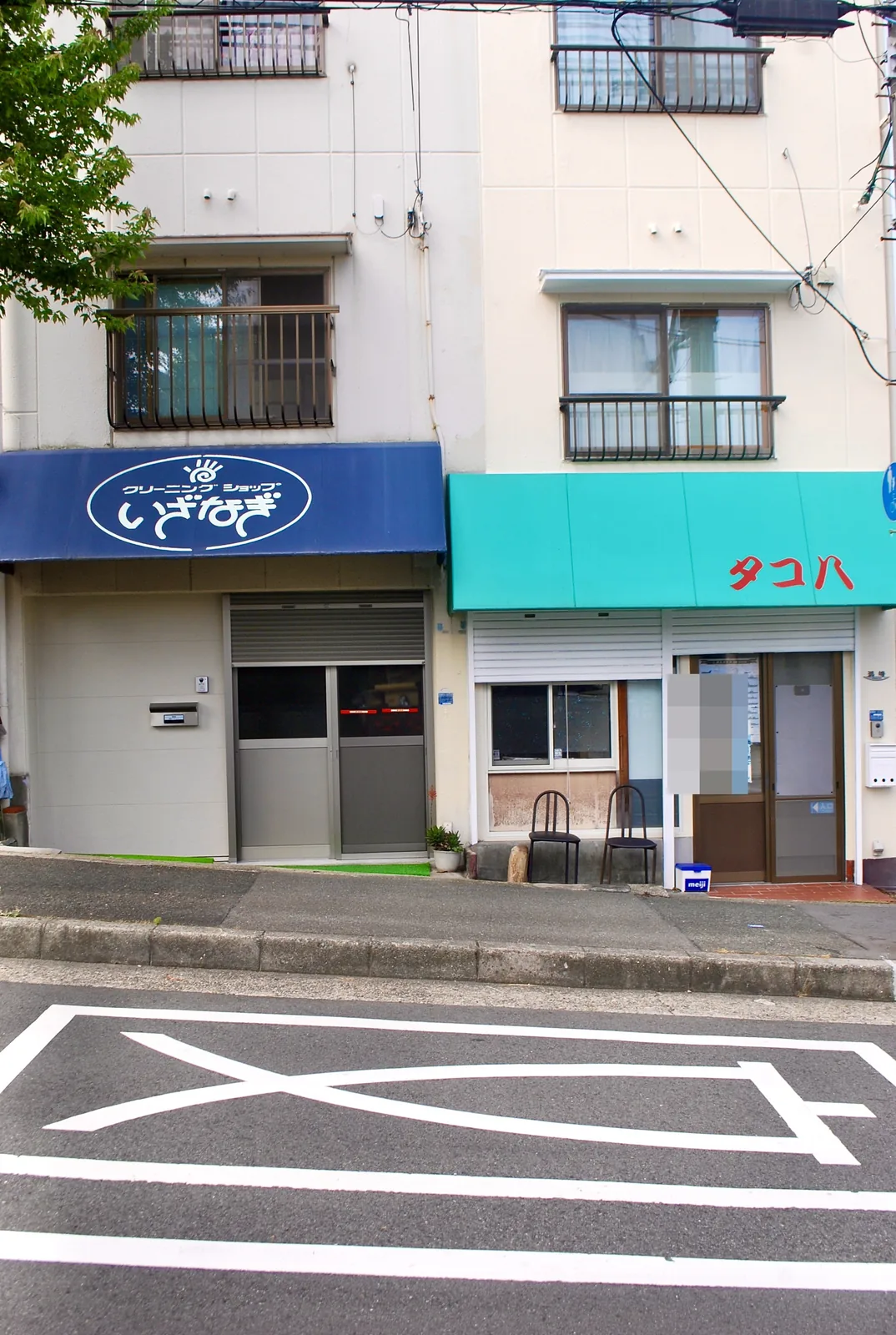 青い日よけのクリーニング店と、水色の日よけの「タコハ」が並ぶ店先