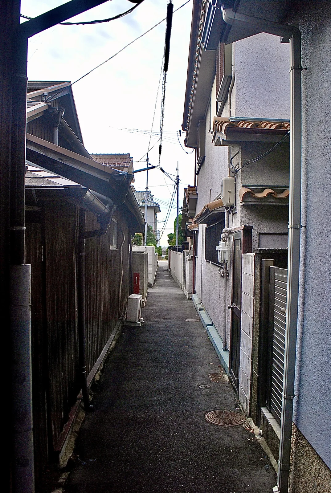 瓦屋根の古い家々に挟まれ、奥へ続く細い路地