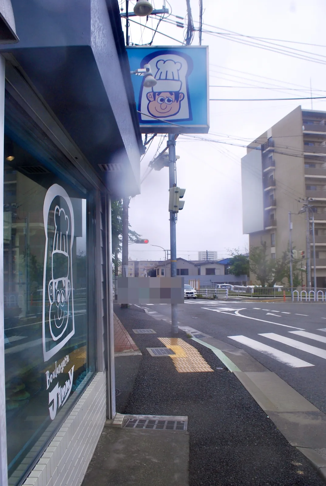 コックさんの絵のあるパン屋の窓と、大通りの交差点