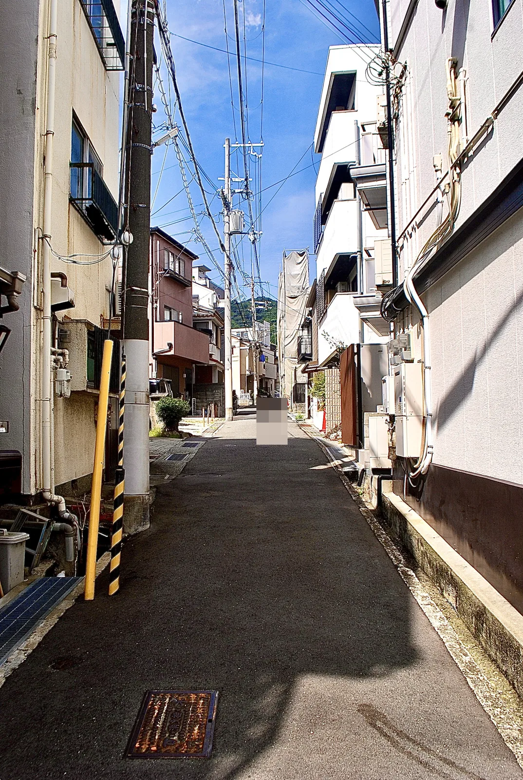 家々と電柱のあいだを、山のほうへまっすぐ続く道