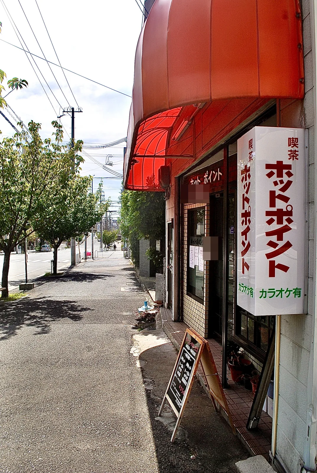 赤い日よけと「喫茶 ホットポイント」の縦看板