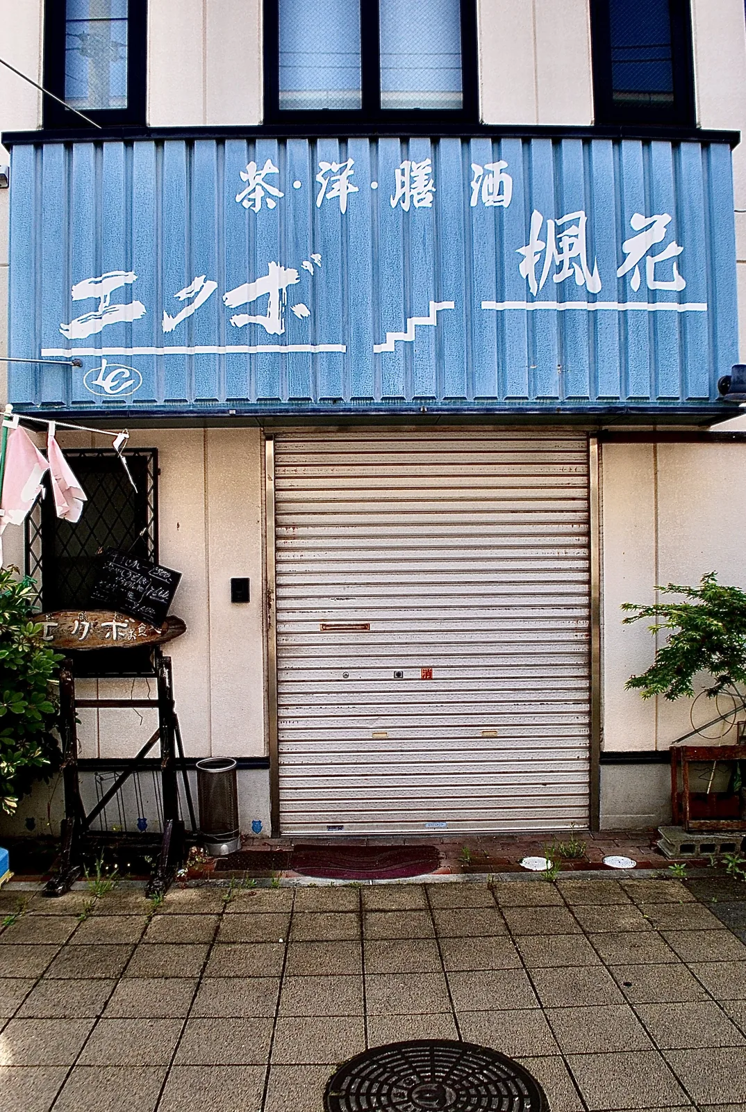 青い看板に「茶洋膳酒 エクボ 楓花」と書かれた、シャッターの店