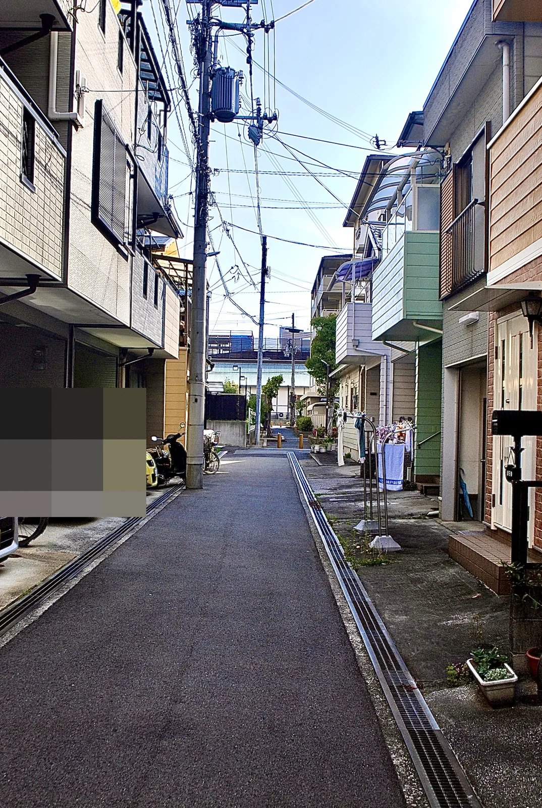 車の止まる家々のあいだを、奥へまっすぐ続く細い道