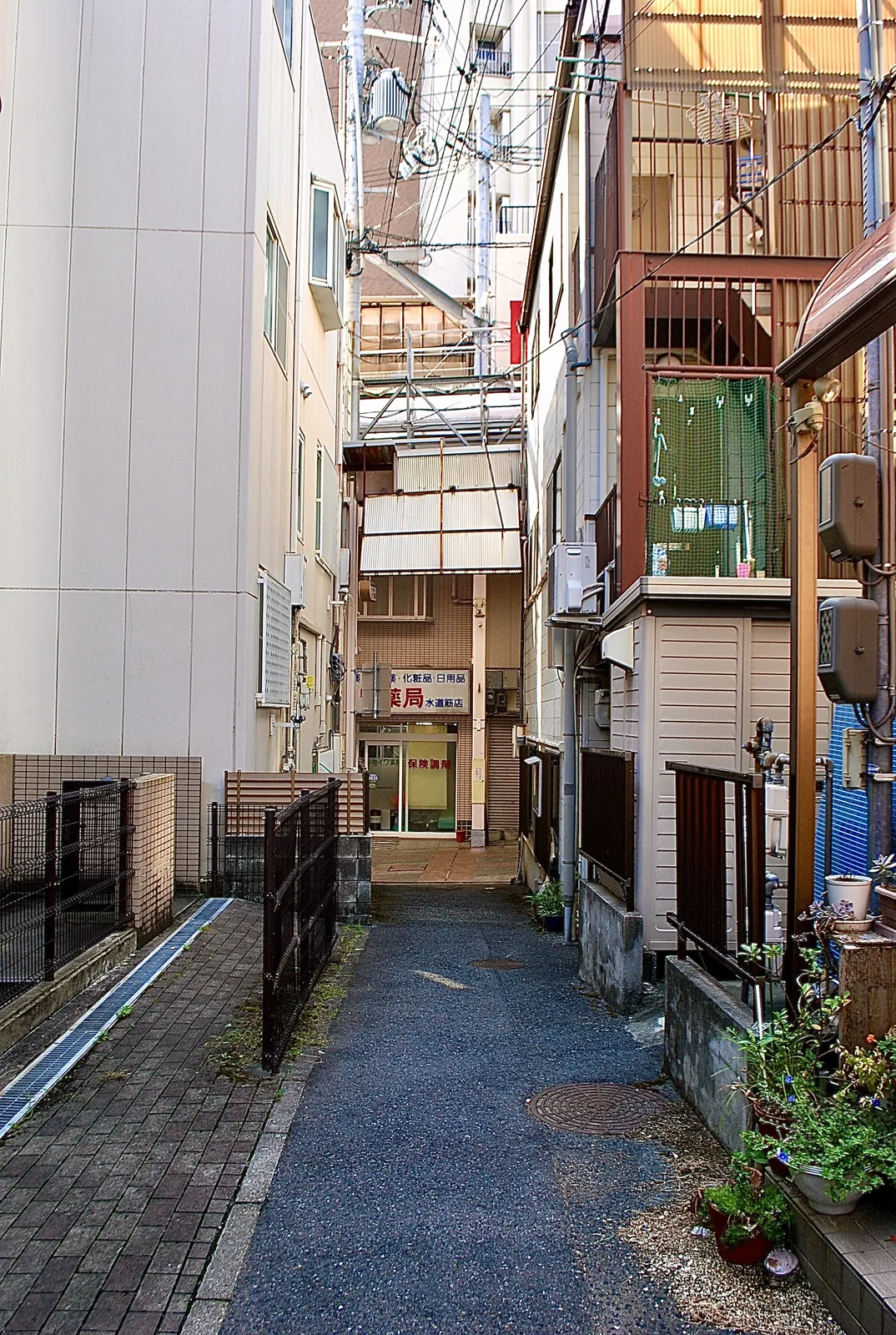 建物に挟まれ、奥の店へ続く細い路地
