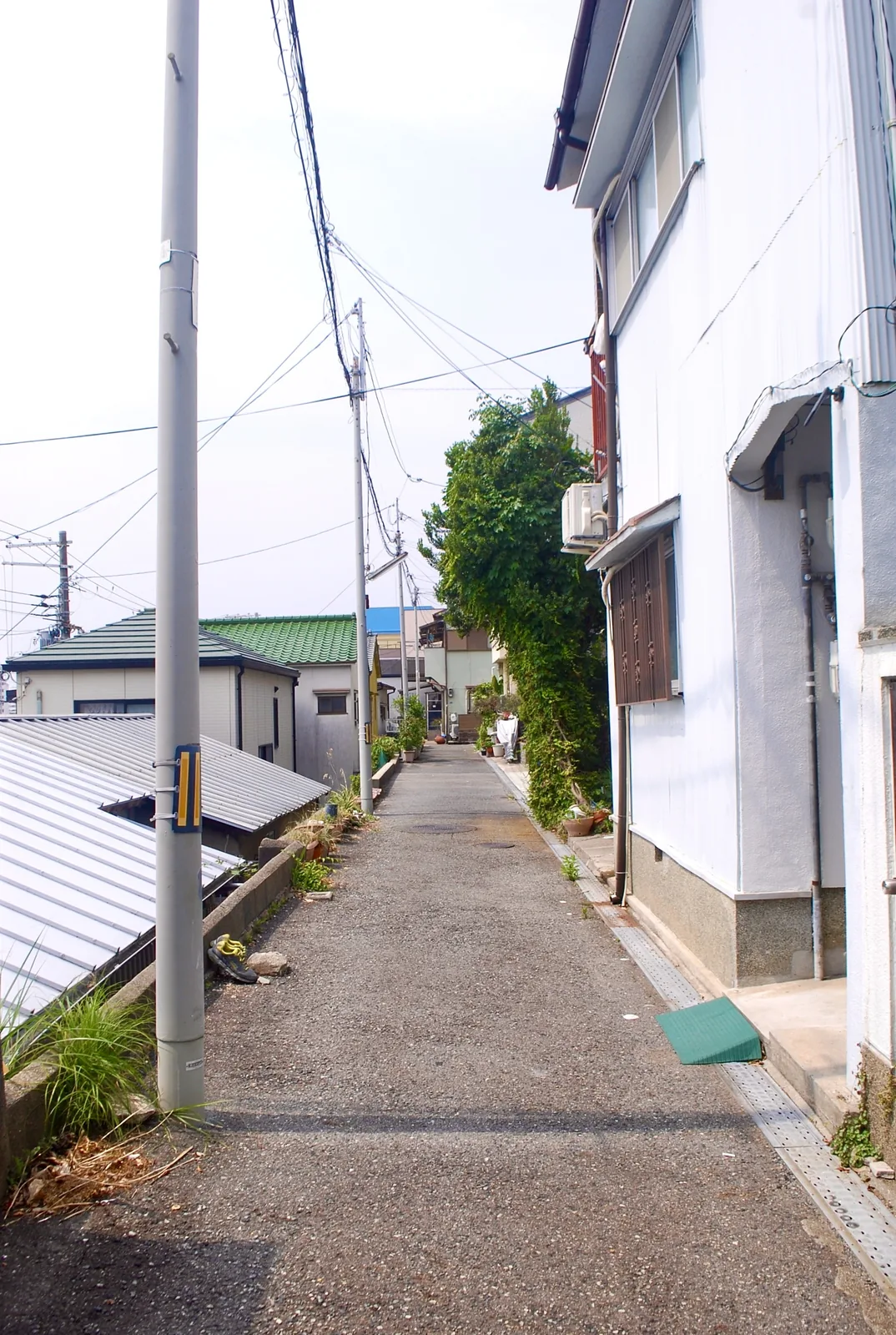トタン屋根と家々のあいだを、奥へまっすぐ続く細い道