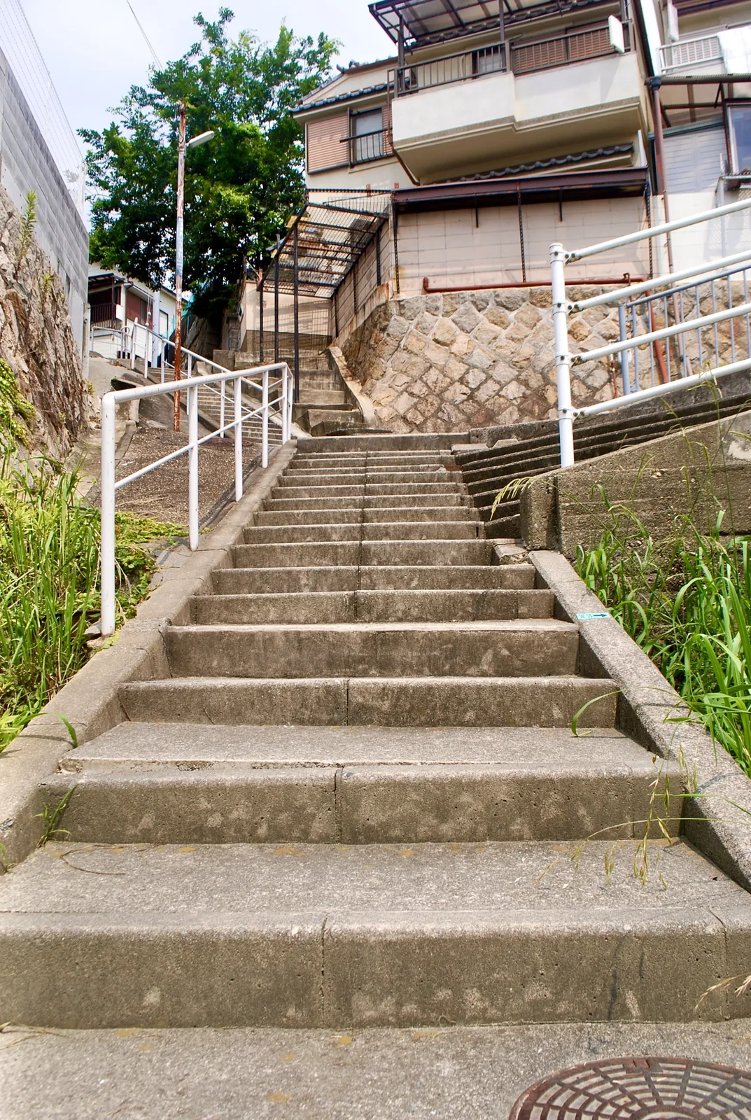 石垣と手すりに挟まれ、まっすぐ上へ続く広い階段
