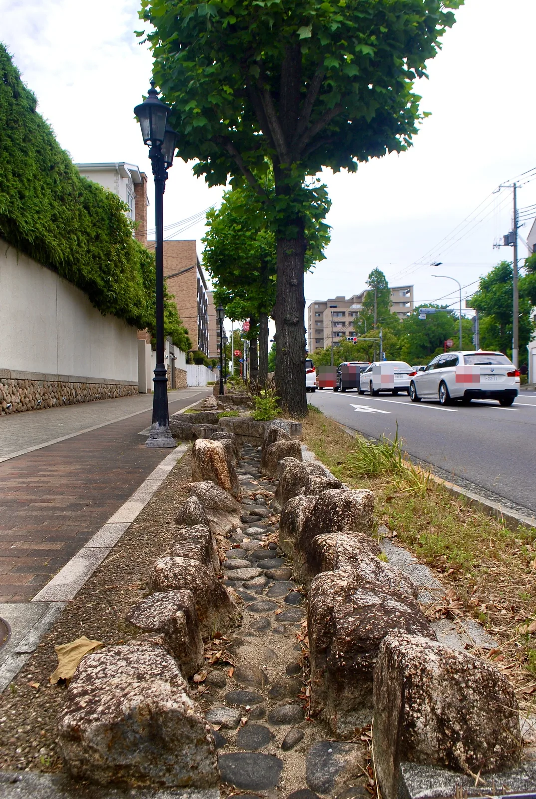 石を並べた小川に沿って、並木と街灯の続く歩道