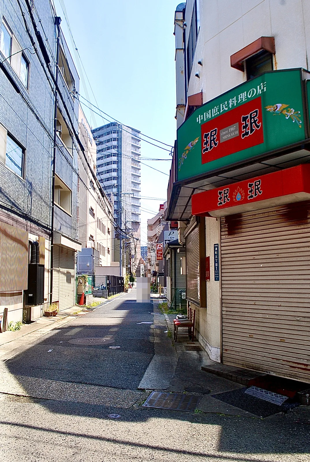 緑と赤の看板の中国庶民料理の店と、奥へ続く細い道