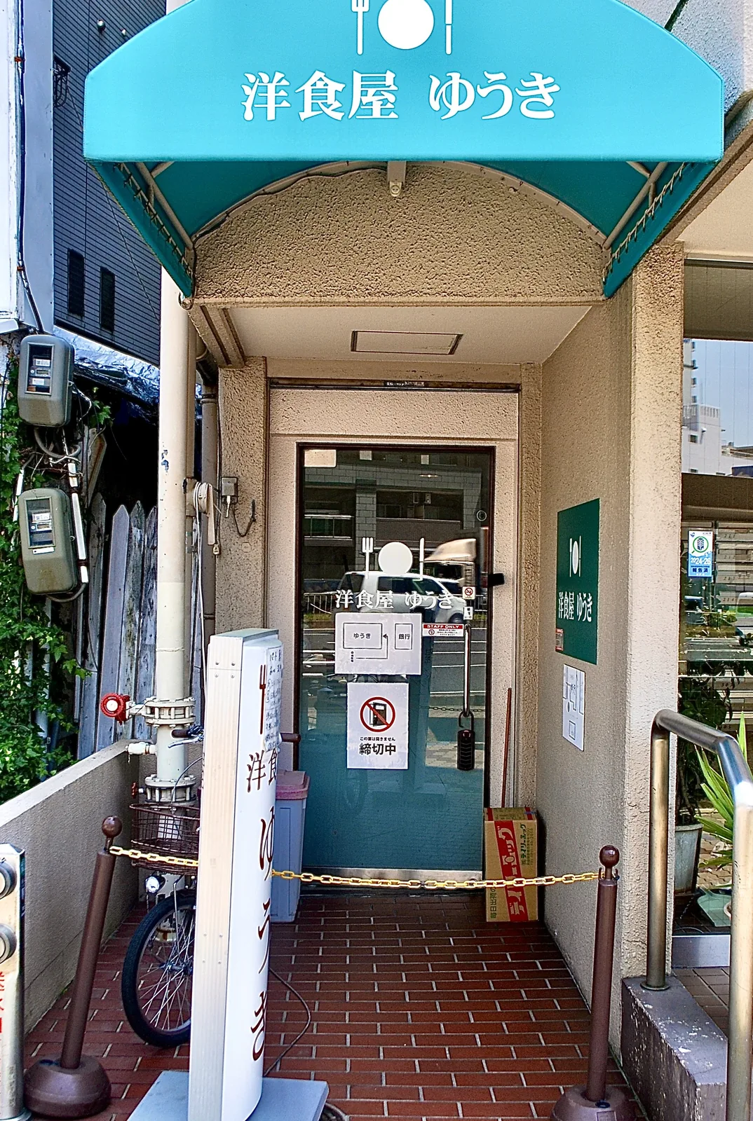 水色の日よけに「洋食屋 ゆうき」と書かれた、レトロな入口