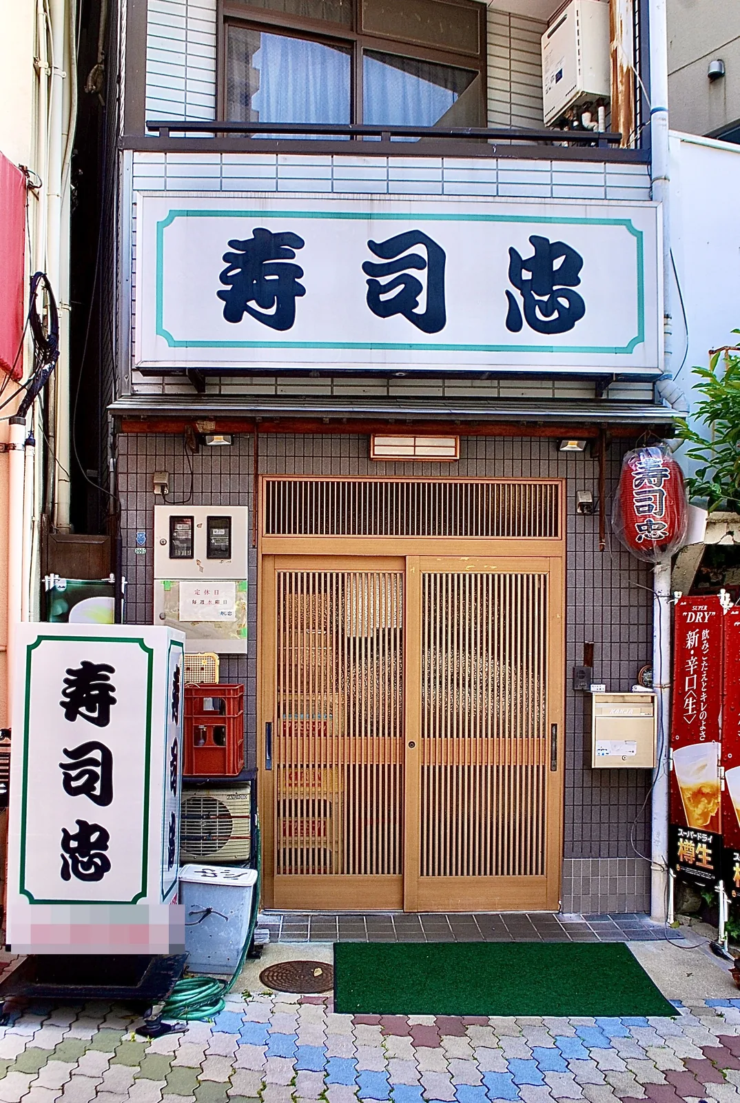 「寿司忠」の看板と提灯、木の格子戸の寿司屋