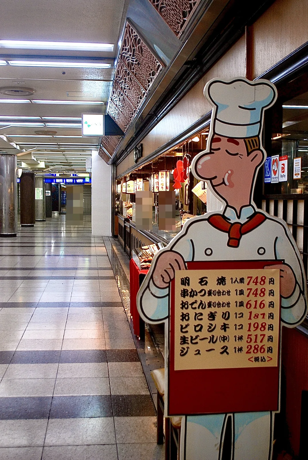 コックさんがメニューを持つ看板と、地下街の店先