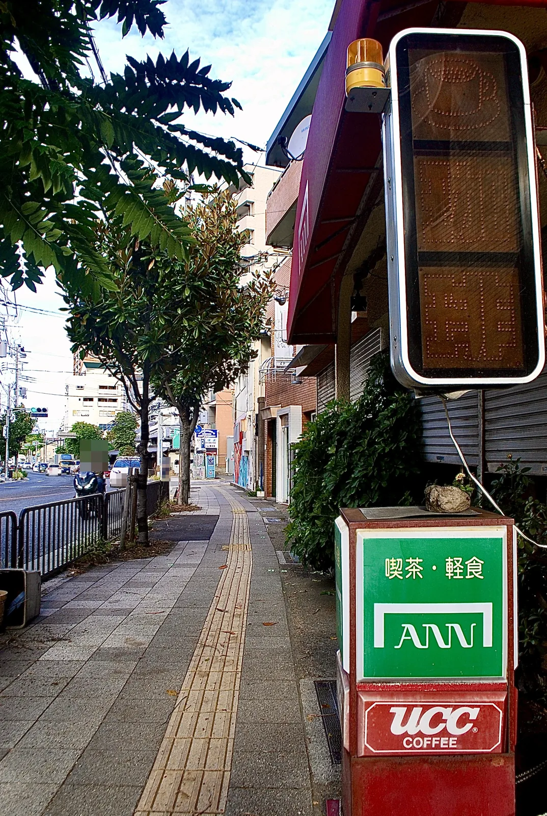 喫茶・軽食の看板が立つ、並木の続く歩道