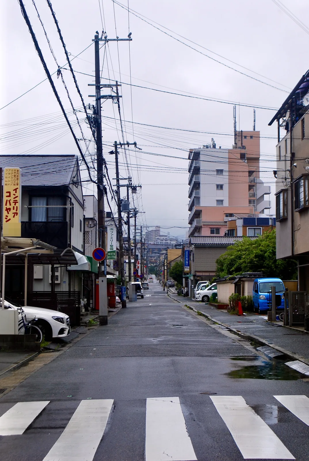 縦長の看板と、電線が幾重にも張られた通り