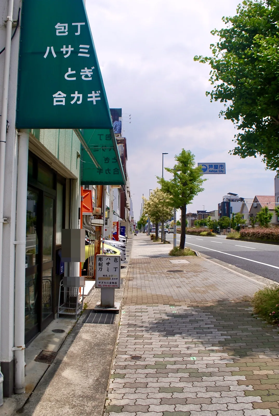 「包丁 ハサミ とぎ 合カギ」の緑の日よけがある金物店