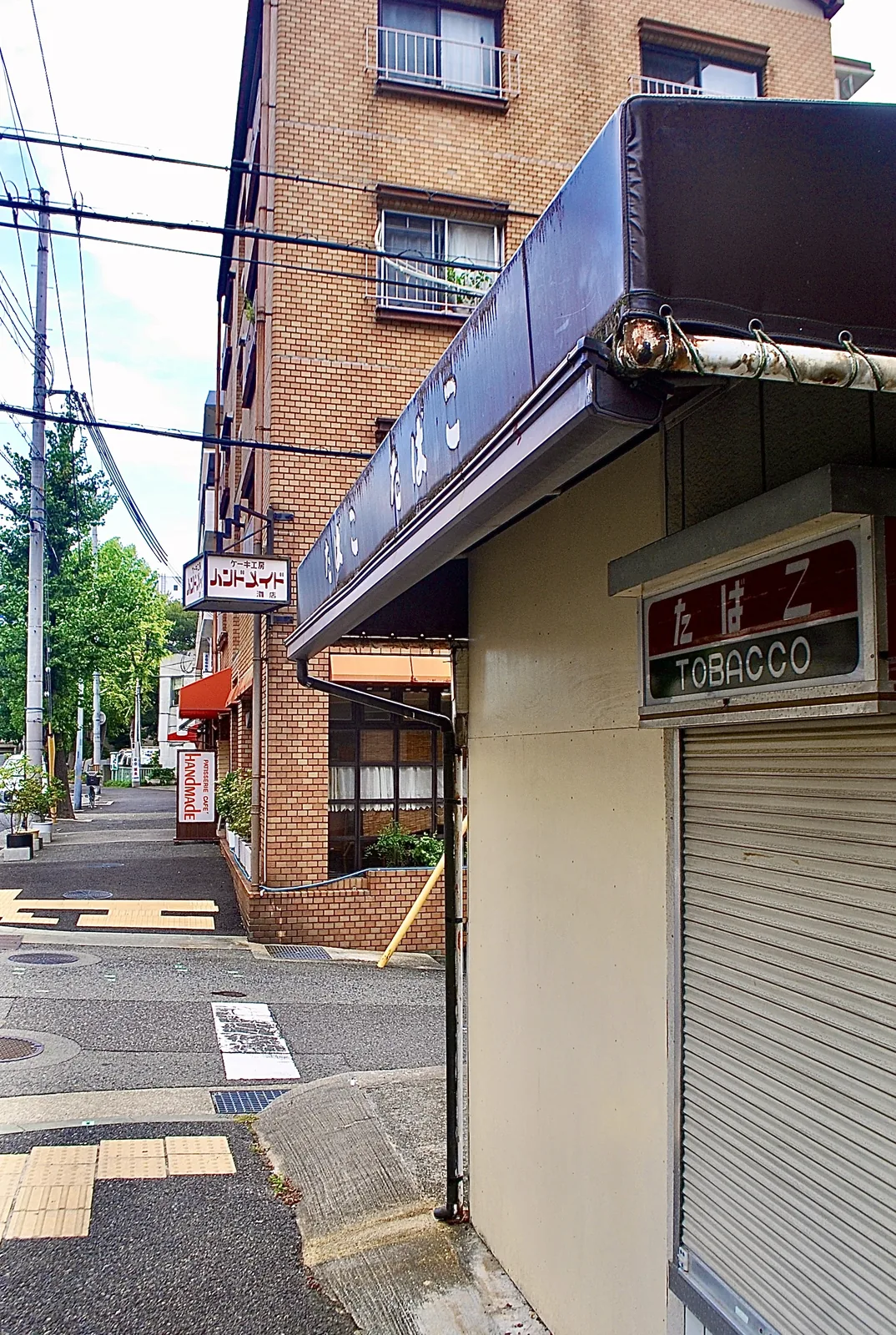 「たばこ TOBACCO」の看板と、ケーキ工房のある角