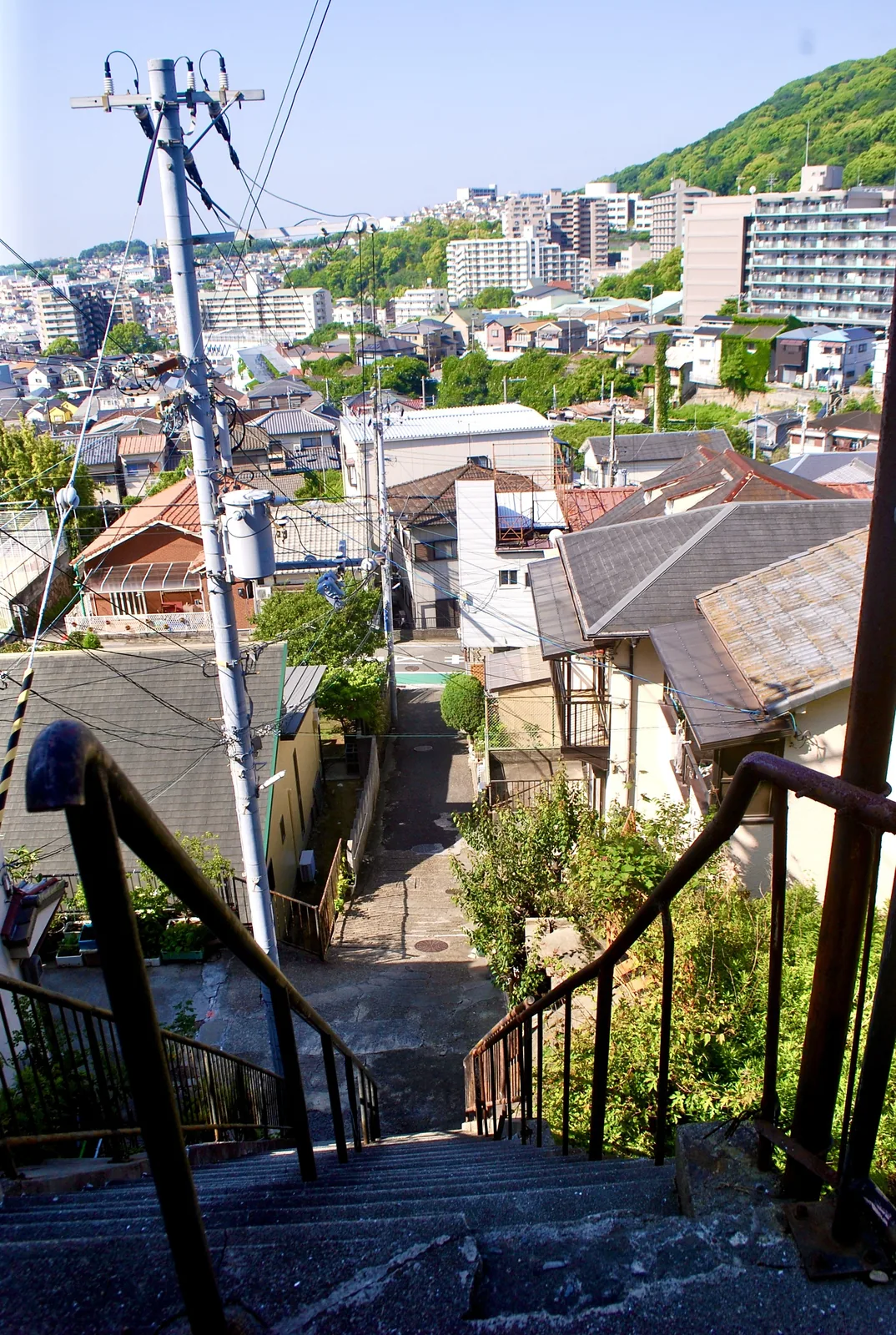 石段の上から、町並みとその奥の山並みを見渡す風景