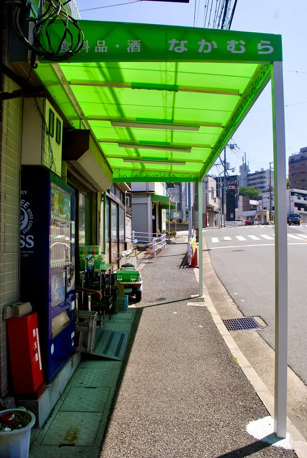 鮮やかな緑の屋根がかかる、角の食料品店