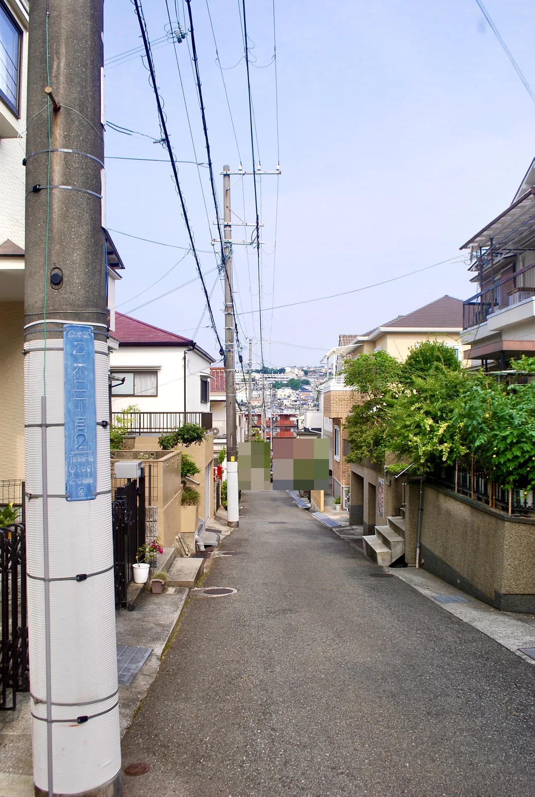 「乙木二丁目」の表示がある電柱と、奥へ続く静かな住宅街の道