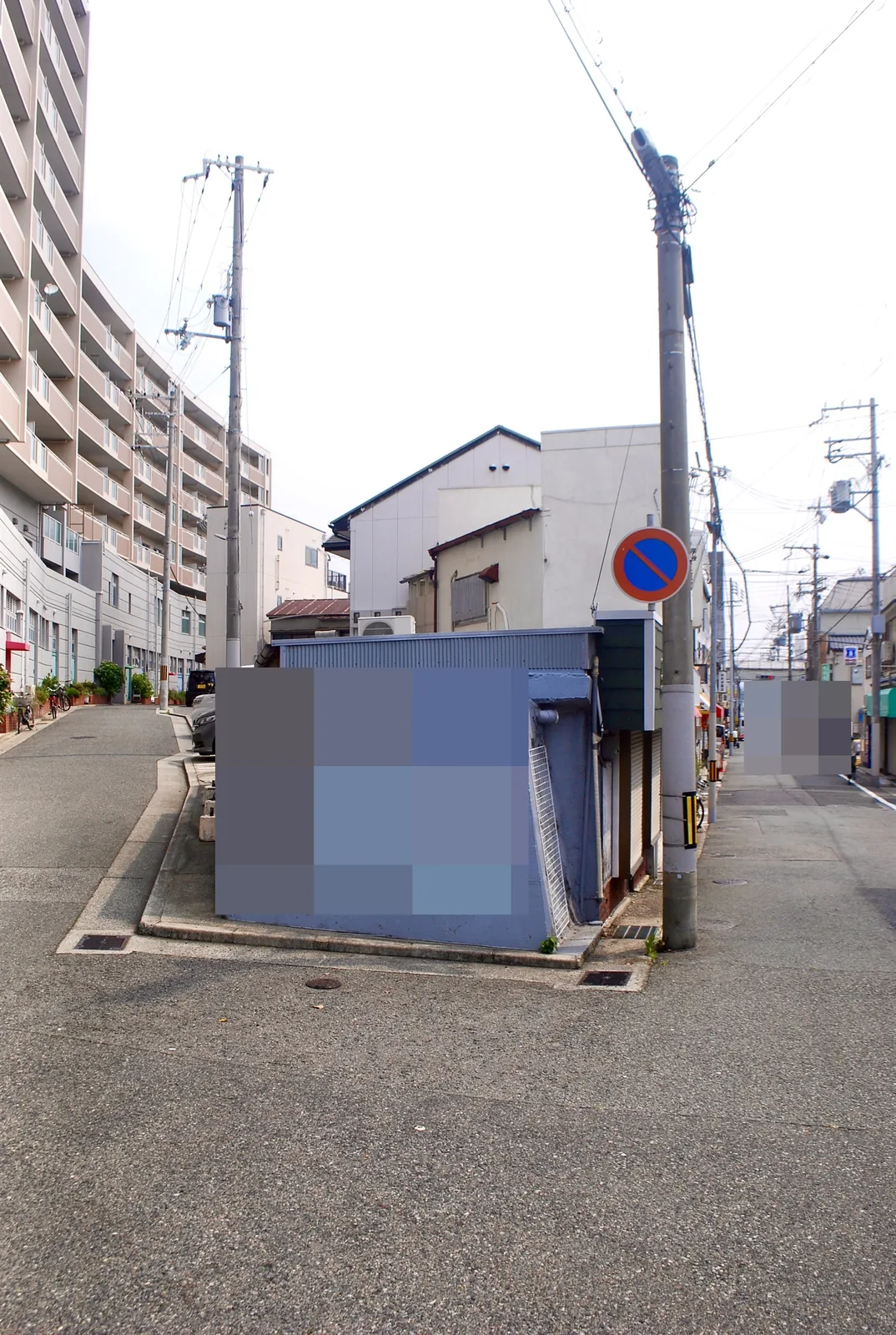 青い壁の小屋の前で分かれ、奥へまっすぐ続く道