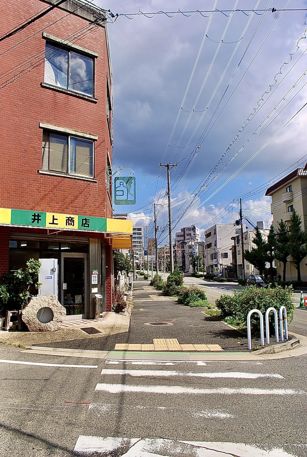 レンガの建物の角にある商店と、電線の張られた交差点