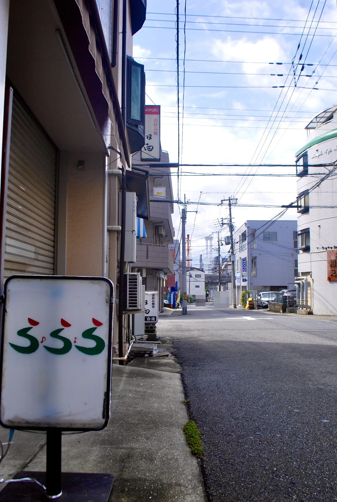 「ふふふ」と書かれた白い看板の先に広がる、静かな交差点